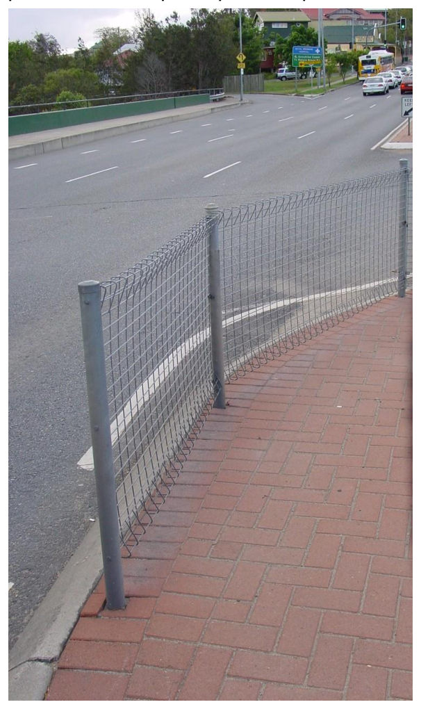 Figure 1.1-E – Pedestrian fences, when installed at medians, should commence at the signal post and not encroach past the push button position